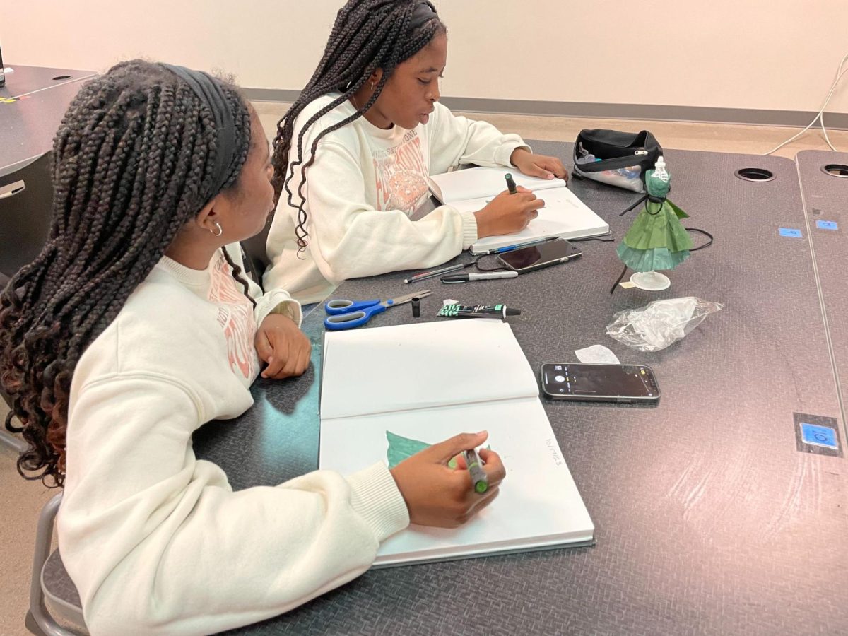  Seniors Kehinde and Taiye Oyelowo work together on their design for the mannequin. Students have been asked to sketch and design a dress out of coffee filters to fit a miniature mannequin. 