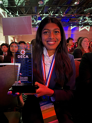 Holding up her award, freshman Tejasvi Kashidi will go to nationals as a DECA competitor for Principles of Marketing. 